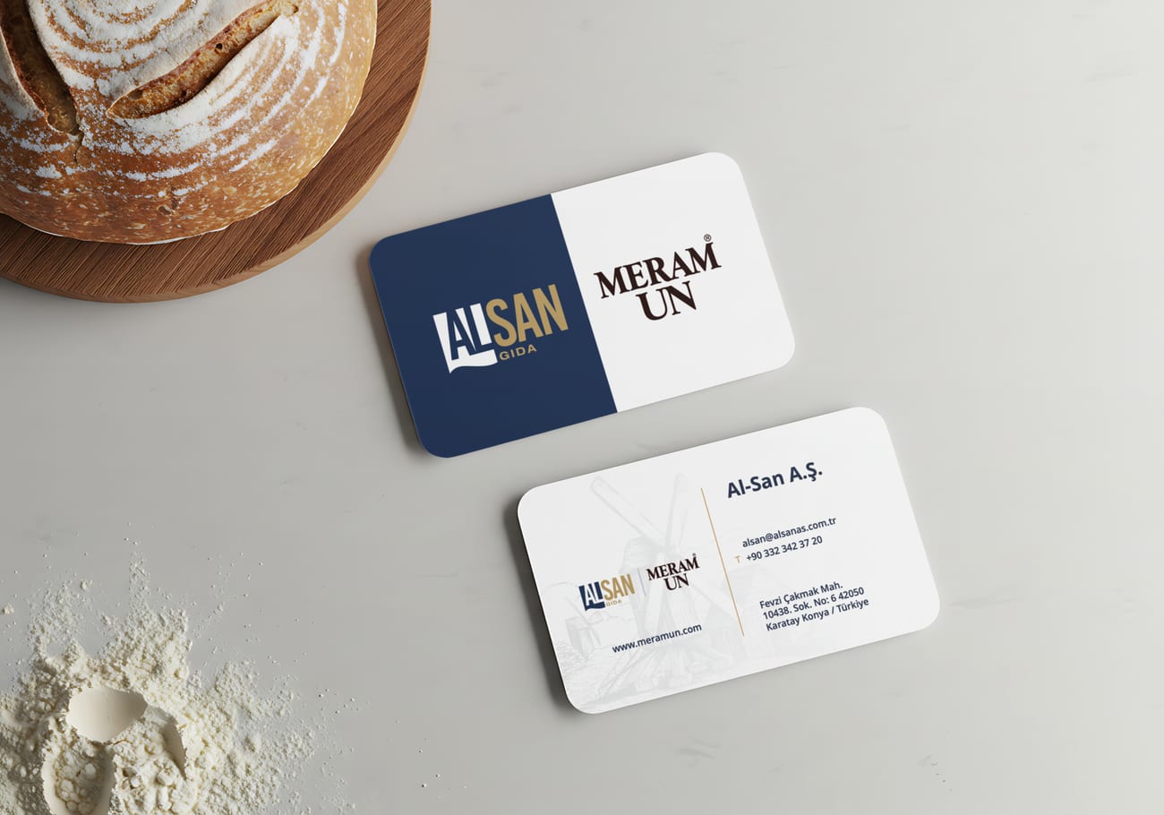 Meram Un — masa üzerine yerleştirilmiş kurumsal kartvizit tasarımı ve un buğday detayı